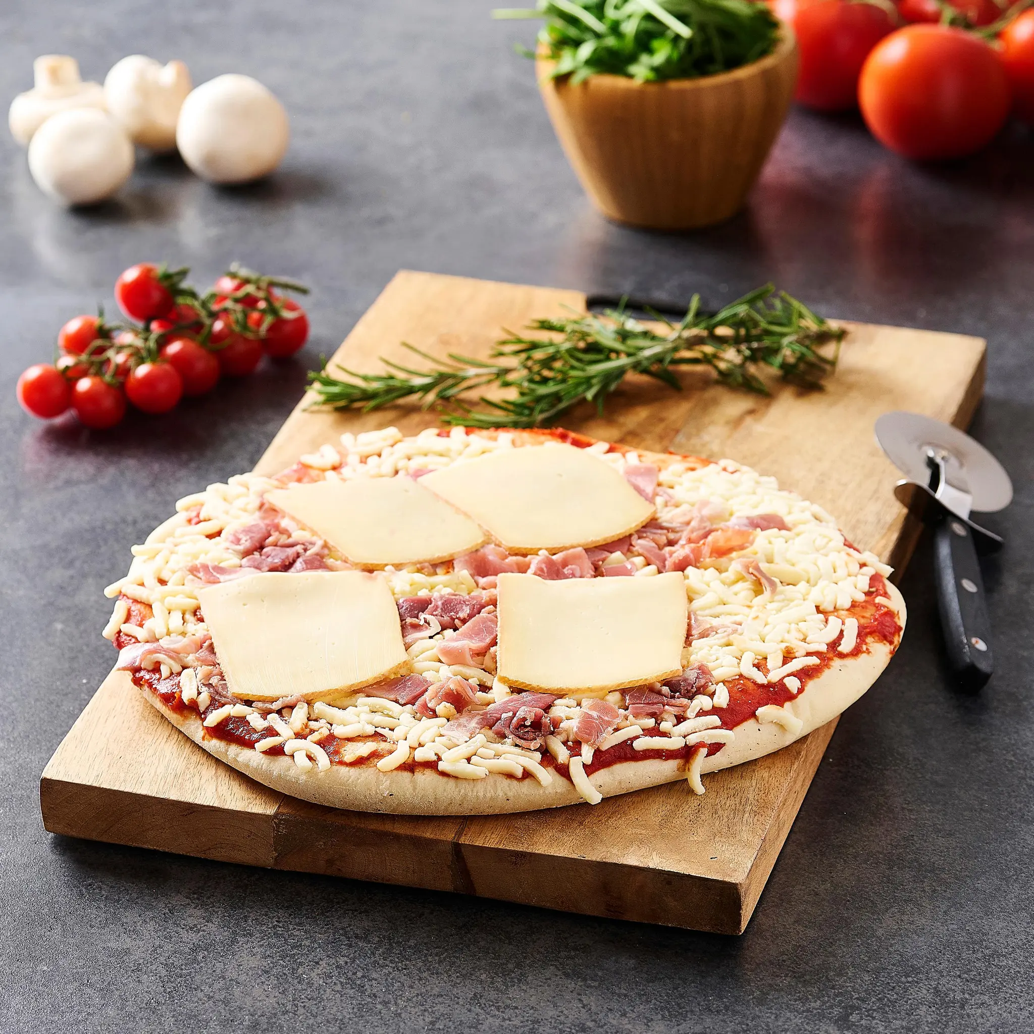 AUCHAN LE TRAITEUR Pizza crue savoyarde au fromage à raclette et au jambon cru sec